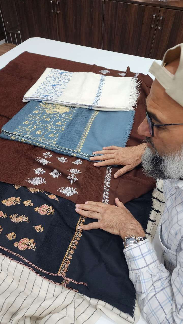 Abbas Bohra, founder of GD Fashion, hand-inspecting shawls in his workshop